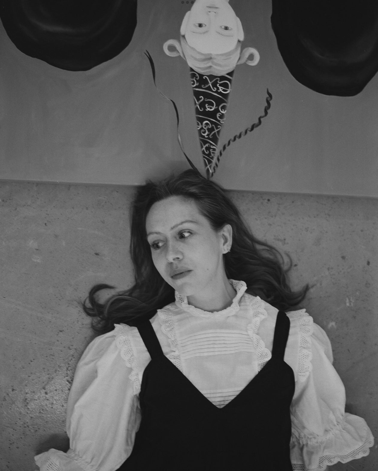 Woman lying on a textured surface with a cartoon character in the background